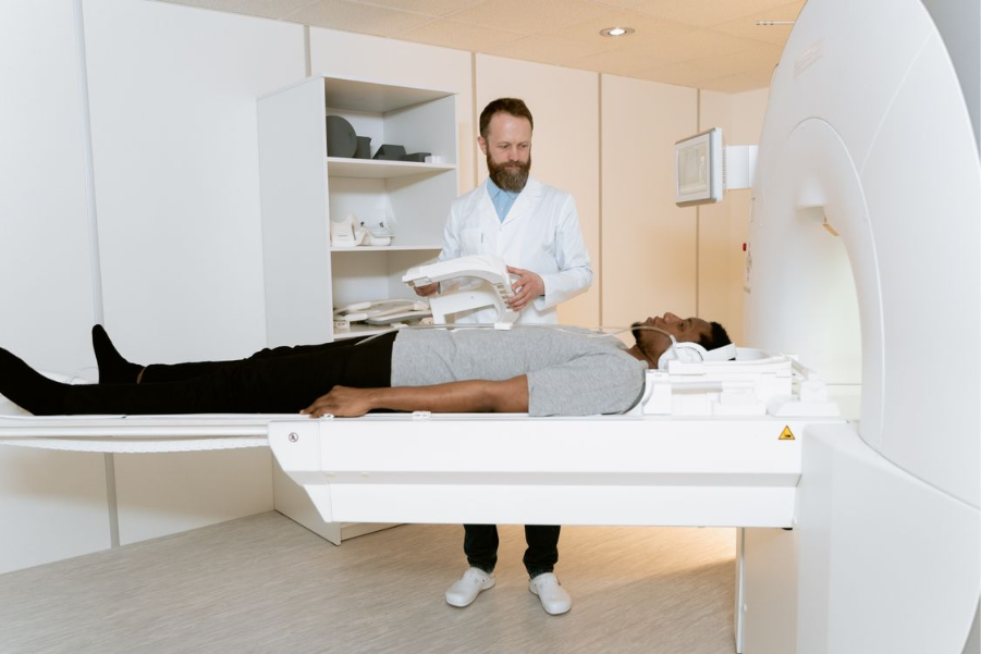 paciente deitado em uma máquina da ultrassonografia ao lado de um operador