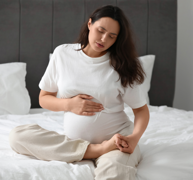 mulher sentada na cama segurando pé direto
