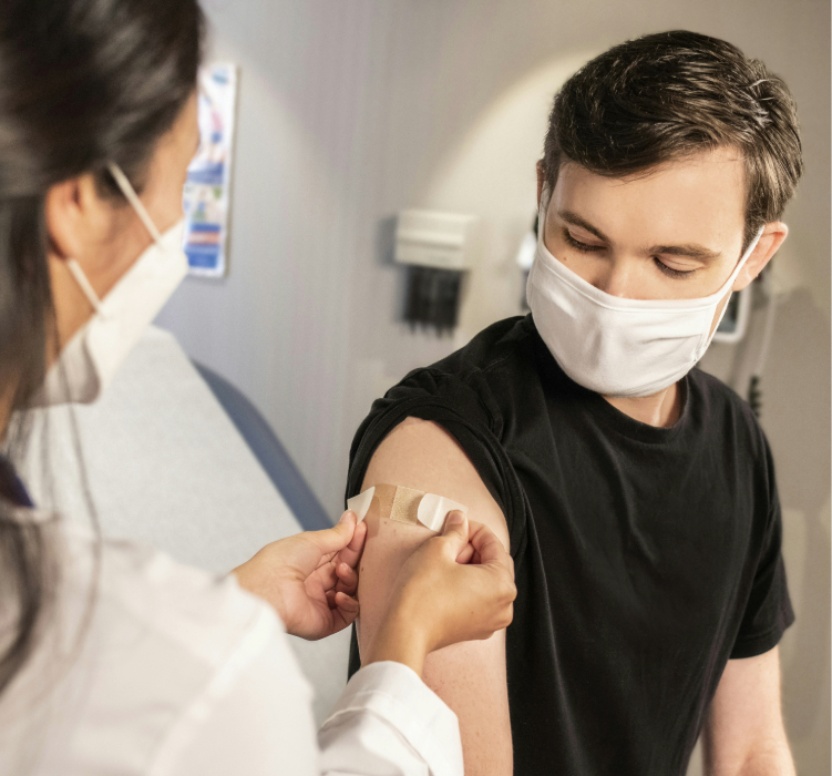 médica colocando um bandaid no braço de um paciente
